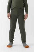 A child wears Cozy Earth’s Children’s Bamboo Waffle Knit Base Layer Pant in Olive, paired with a matching long-sleeve top and gray socks with orange toes, standing against a plain white background. The child’s face is not shown.|Color:Olive