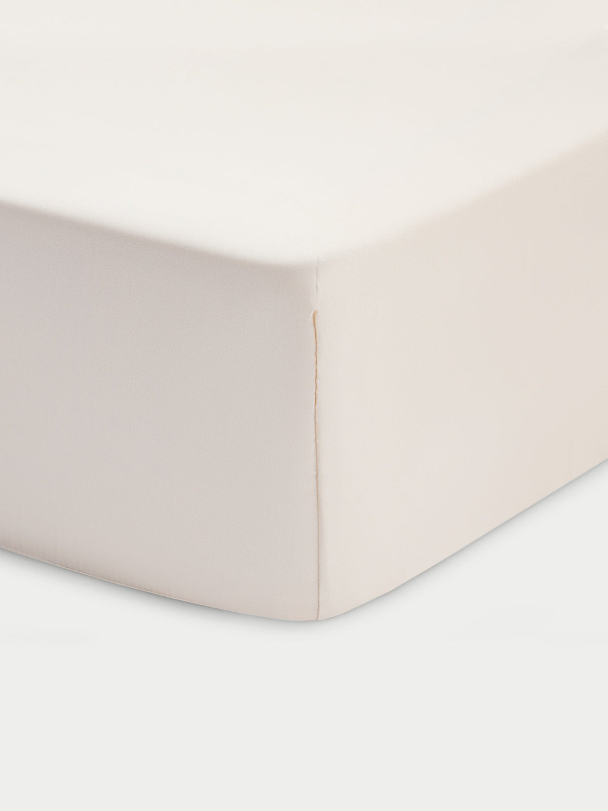 Corner of creme crib sheet with white baackground |Color:Creme