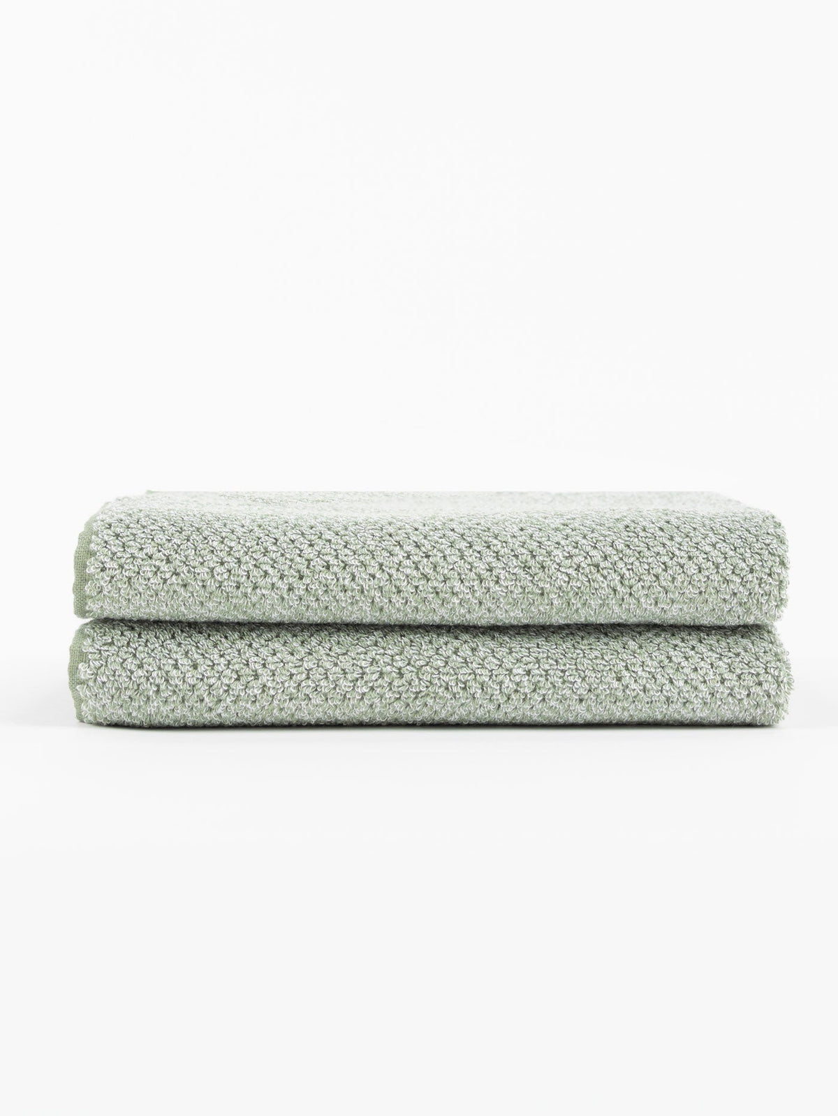 Two neatly folded Nantucket Bath Towel Set towels by Cozy Earth, in light gray with a textured finish, are stacked atop each other against a plain white background.|Color:Heathered Sage