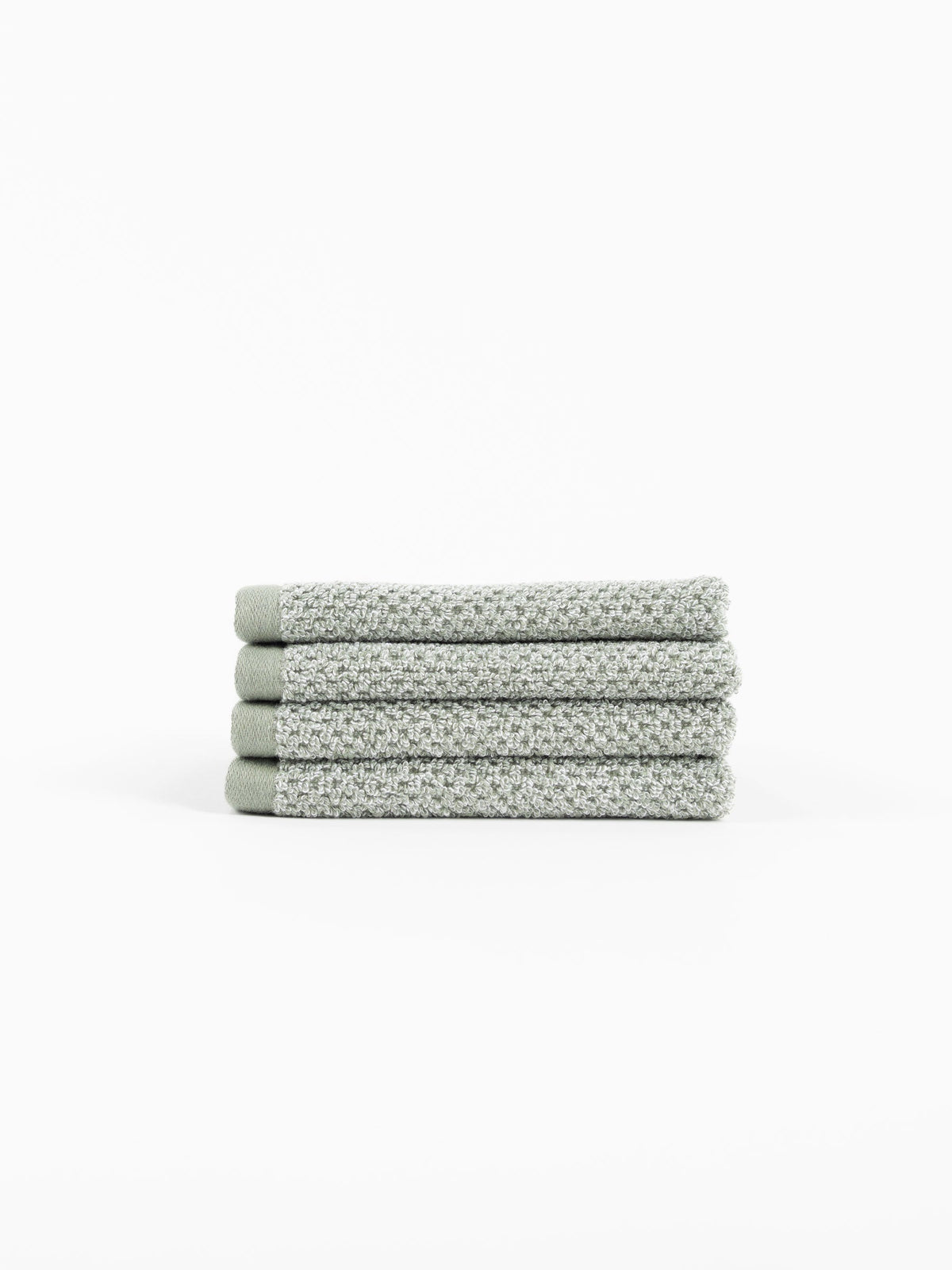 A neatly folded stack of four Cozy Earth Nantucket Bath Towels in textured light gray rests on a white background.|Color:Heathered Sage