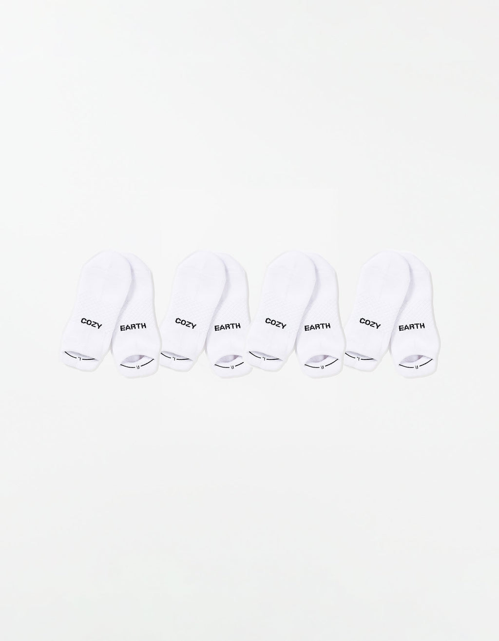 The Essential Ankle Sock 4-Pack by Cozy Earth features four pairs of white ankle socks, each with "COZY" and "EARTH" printed in black on top, arranged in a row on a white background. |Color:White