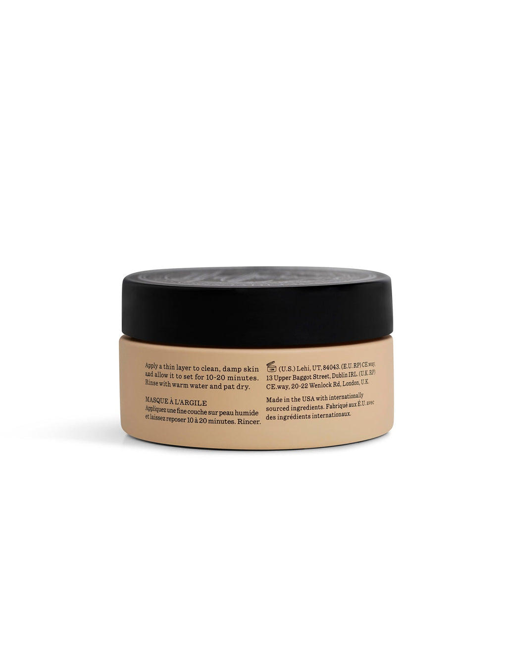 A beige jar labeled "Clay Mask" by Cozy Earth, with a black lid, is shown from the side. Black text on the jar displays product instructions and info, highlighting its use as a skincare item.