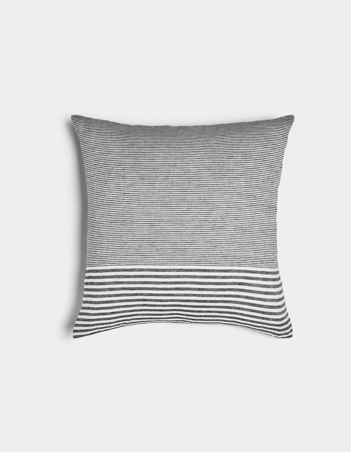 The Cozy Earth Striped Throw Pillow features thin black and white horizontal stripes with a bold band of thicker stripes at the bottom, set against a plain white background.|Color:Mixed Stripe Eclipse and Sea Salt |Size:20" x 20"