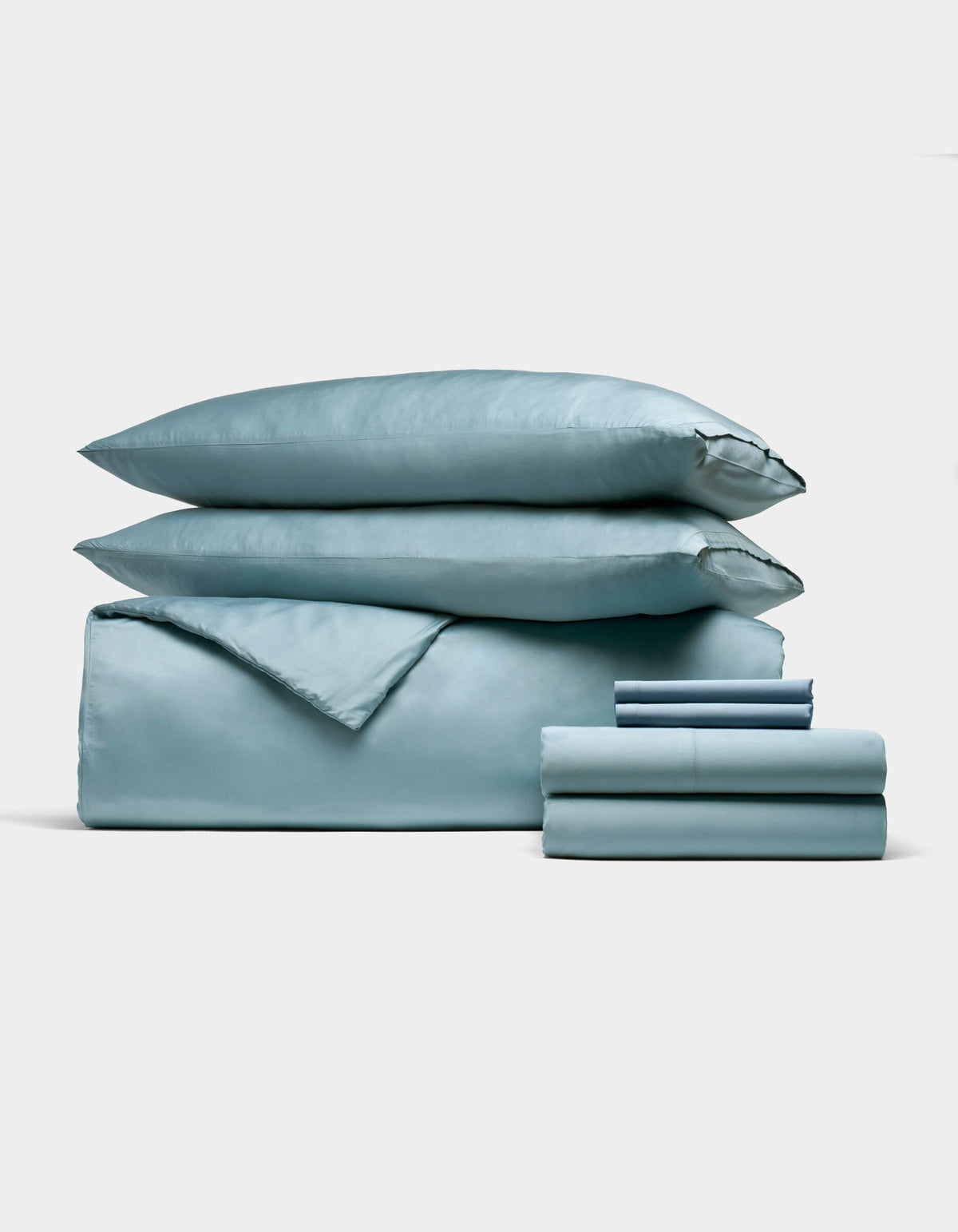 The Cozy Earth Bamboo Bedding Ultimate Bundle, featuring a light blue duvet cover, two pillows, and neatly folded sheets, is displayed against a white background.|Color:River