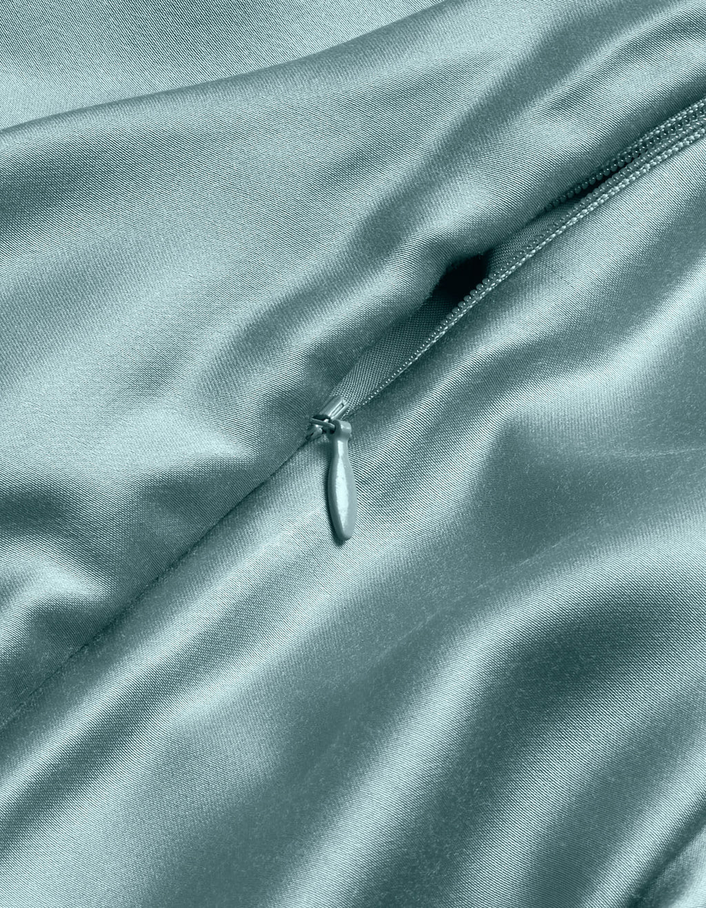 A close-up of the Cozy Earth Bamboo Duvet Cover in light blue shows its shiny, delicate satin texture with a partially unzipped zipper highlighting the smooth, luxurious folds.|Color:River