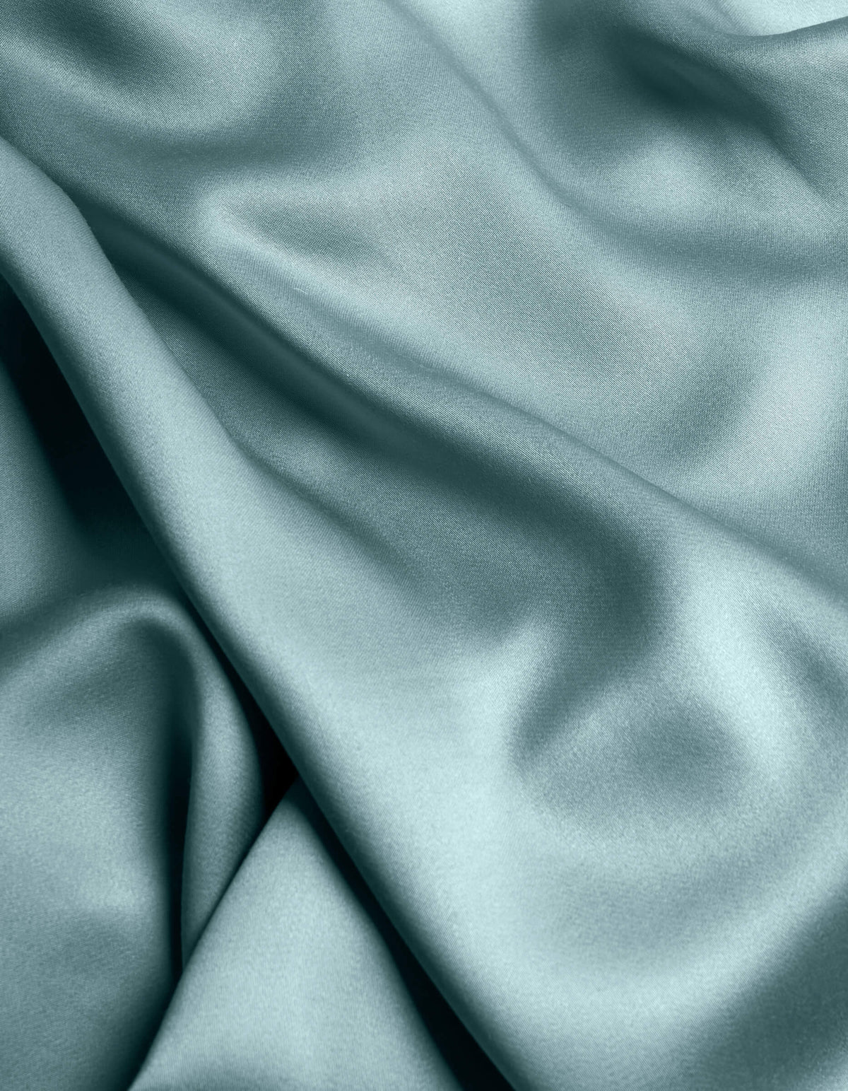 The Cozy Earth Bamboo Sheet Set features smooth, light blue satin fabric with gentle folds and a soft, flowing texture for a shiny, elegant look.|Color:River