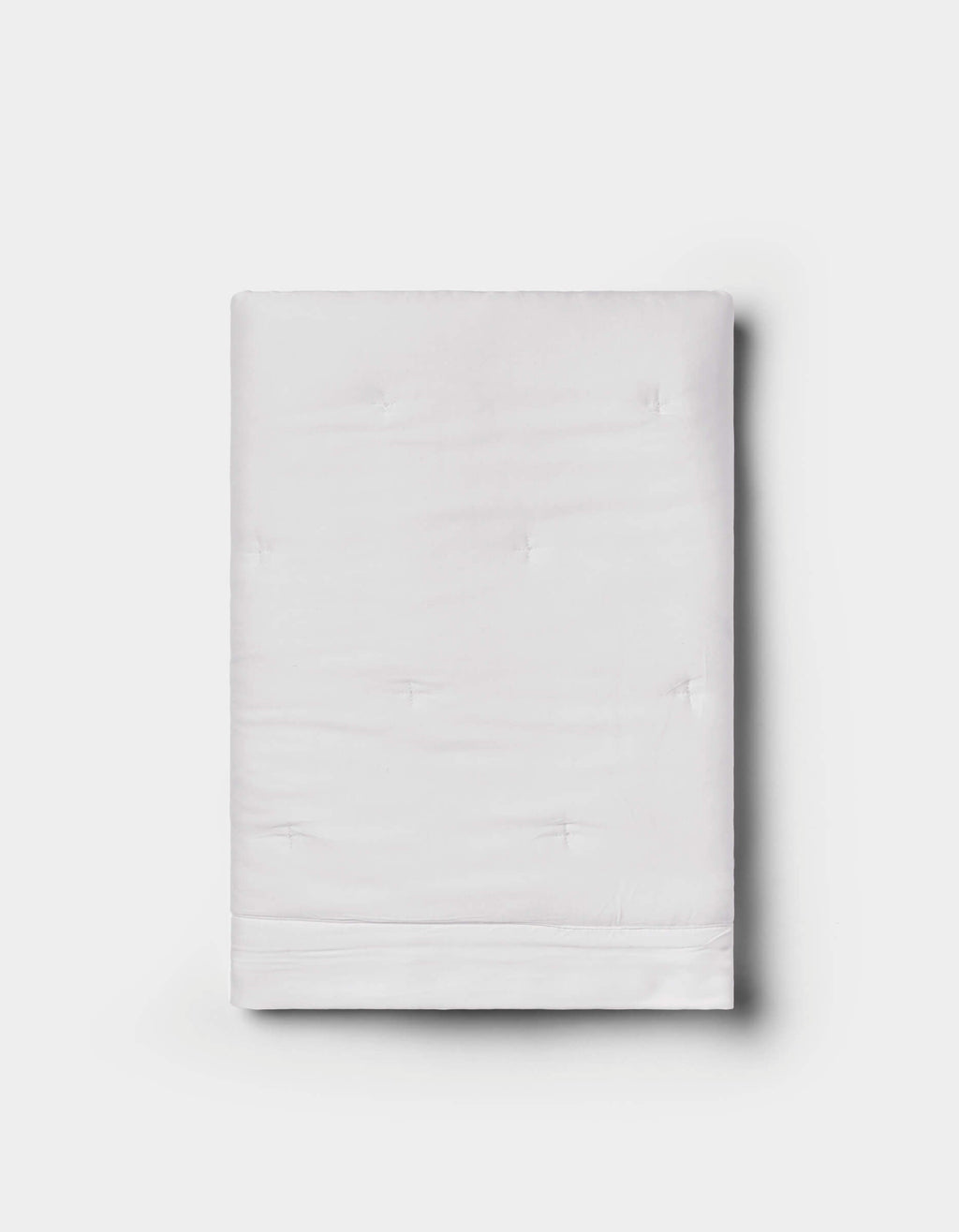 The Bamboo Quilted Shams by Cozy Earth are neatly folded, featuring a subtle quilted texture in white, displayed against a plain light gray background.|Color:White