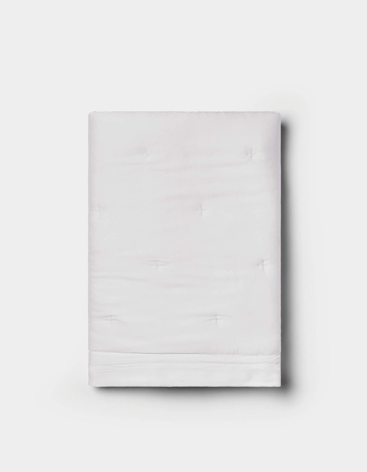 The Bamboo Quilted Shams by Cozy Earth are neatly folded, featuring a subtle quilted texture in white, displayed against a plain light gray background.|Color:White