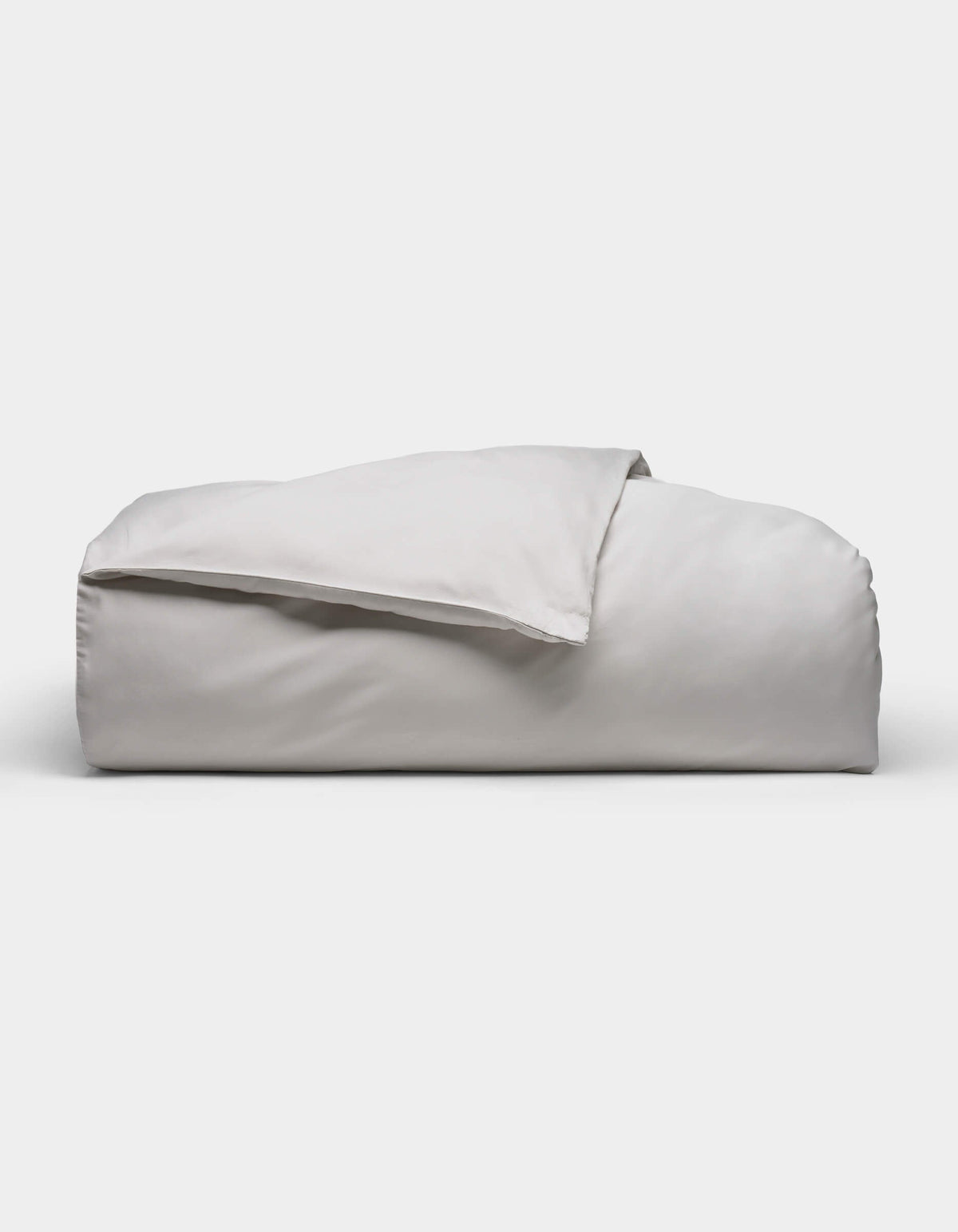 The Soft-Wash Cotton Duvet Cover by Cozy Earth, shown neatly folded in light gray with a smooth, soft texture, is displayed against a plain white background.|Color:Dew