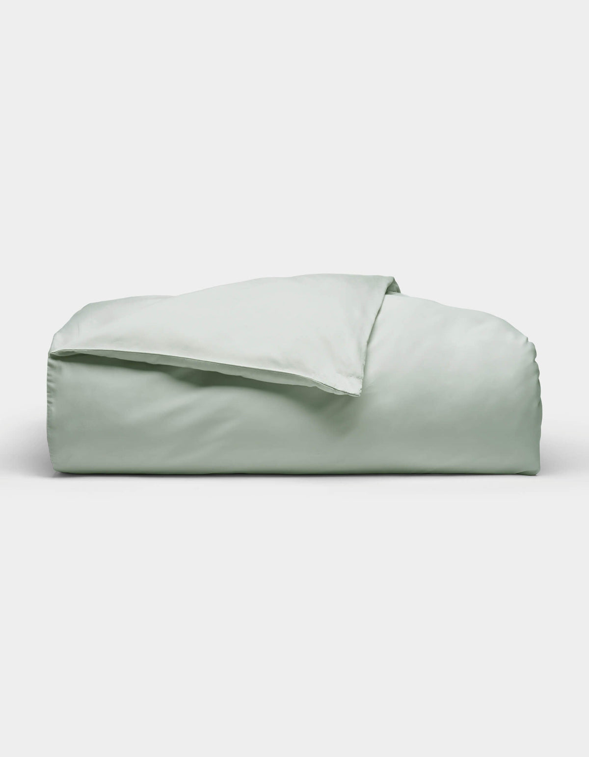 The Soft-Wash Cotton Duvet Cover by Cozy Earth, shown neatly folded in light green, is displayed against a plain white background.|Color:Laurel