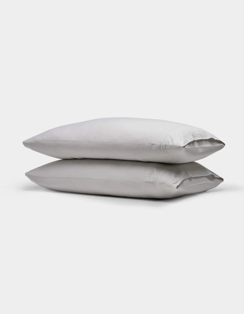 Two stacked, rectangular Soft-Wash Cotton Pillowcases by Cozy Earth in light gray are shown on a plain white background.|Color:Dew
