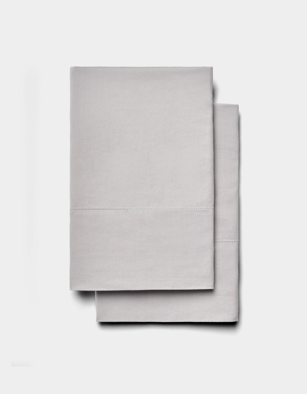 Two neatly folded Soft-Wash Cotton Sheet Sets by Cozy Earth in light gray are stacked on a plain white background.|Color:Dew