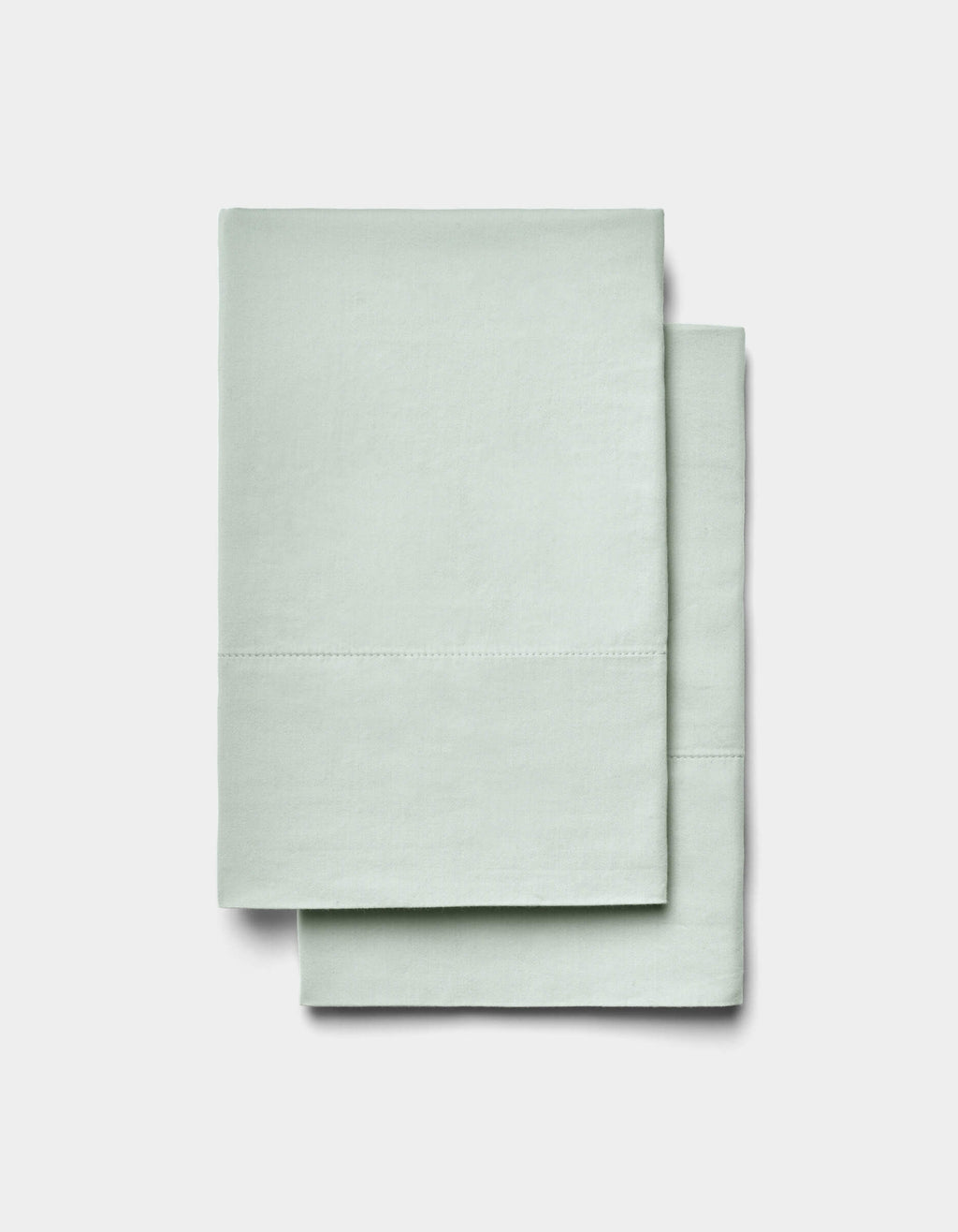 Two neatly folded Soft-Wash Cotton Sheet Set items by Cozy Earth in light mint green are stacked on a plain white background.|Color:Laurel