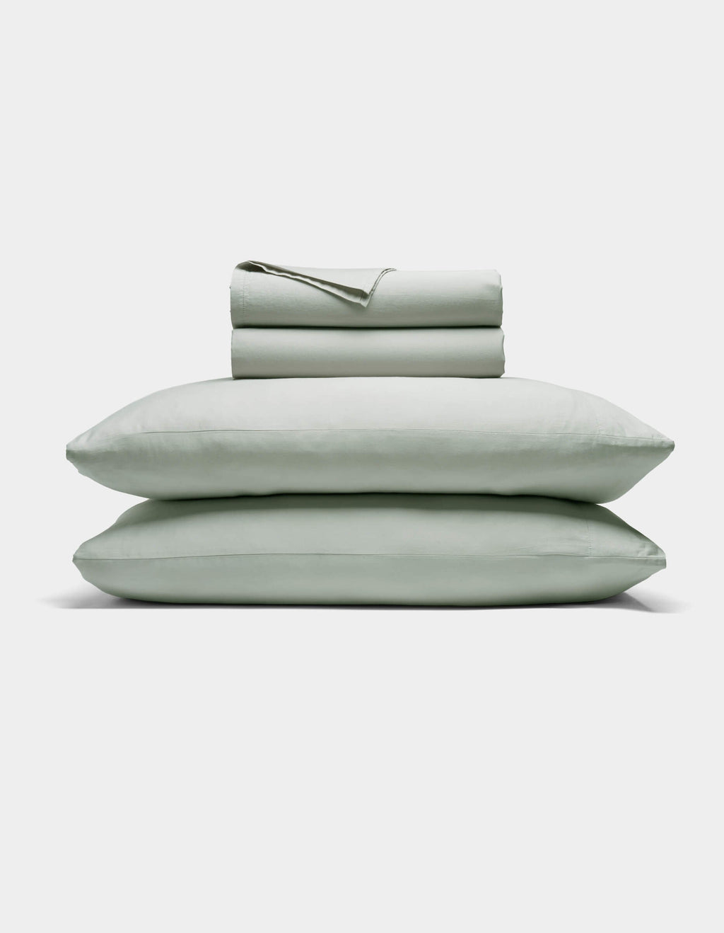 The Cozy Earth Soft-Wash Cotton Sheet Set includes a neatly folded light gray fitted and flat sheet with two stacked pillows, displayed against a plain white background.|Color:Laurel