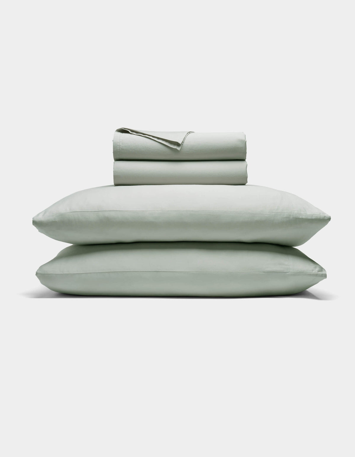 The Cozy Earth Soft-Wash Cotton Sheet Set includes a neatly folded light gray fitted and flat sheet with two stacked pillows, displayed against a plain white background.|Color:Laurel