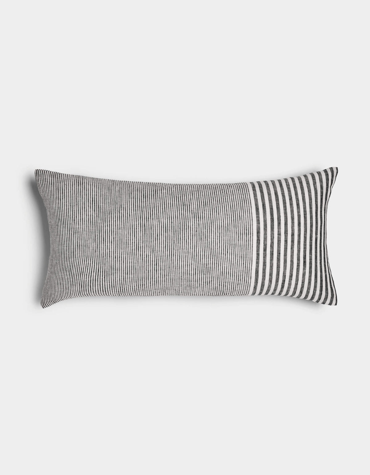 The Cozy Earth Striped Throw Pillow features thin vertical black and white stripes across most of its rectangular surface, with wider stripes at one end, displayed against a plain white background.|Color:Mixed Stripe Eclipse and Sea Salt |Size:14" x 30"