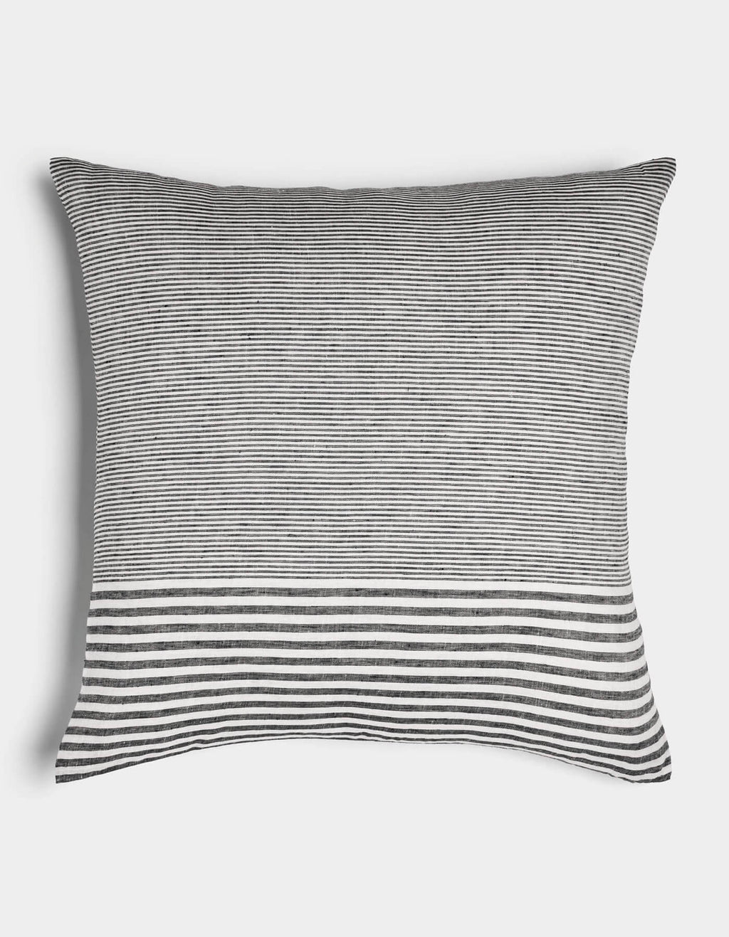 The Cozy Earth Striped Throw Pillow features thin black and white horizontal stripes with a bold, wider band at the bottom on a plain white background.|Color:Mixed Stripe Eclipse and Sea Salt |Size:26" x 26"