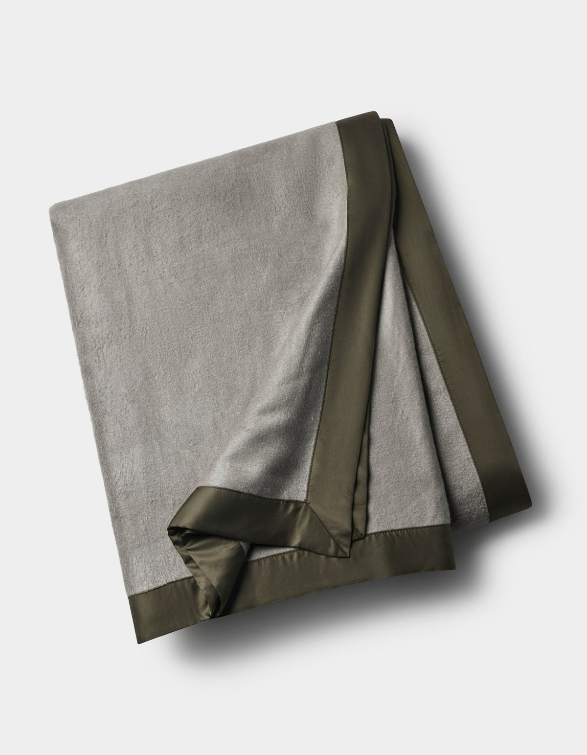 The Cozy Earth Bamboo Blanket, in light gray with a dark satin border, is neatly folded and displayed on a white background.|Color:Sage/Olive