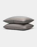 Two neatly stacked Bamboo Coverlet Shams by Cozy Earth in gray with stripes, displayed on a plain white background.|Color:Charcoal