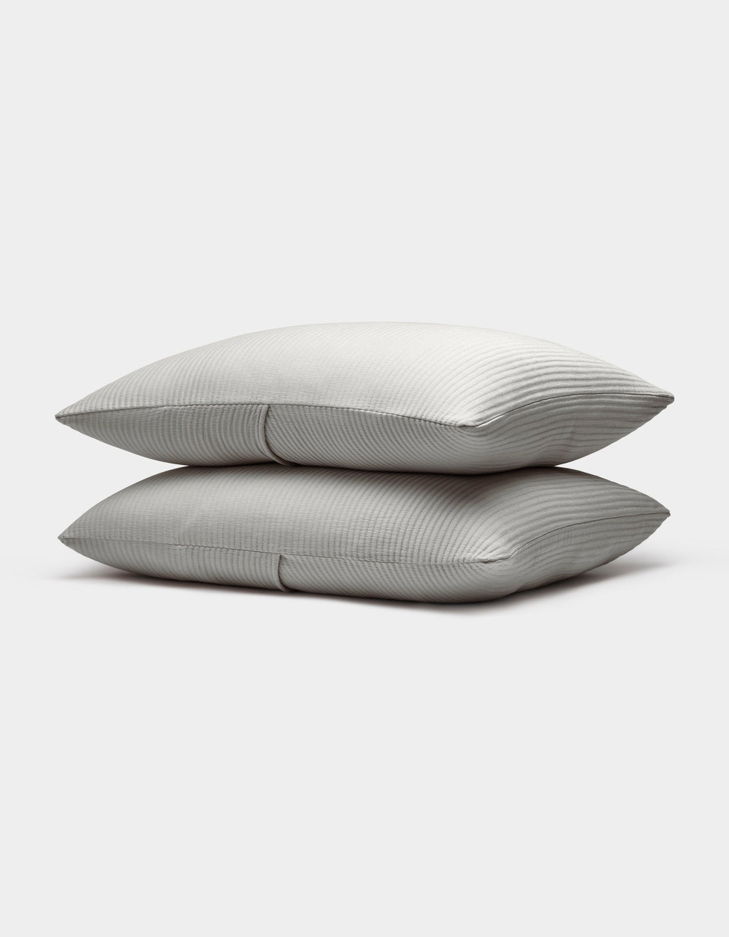 Two neatly stacked Bamboo Coverlet Shams by Cozy Earth, light gray with a subtle striped pattern, are displayed on a plain white background.|Color:Light Grey
