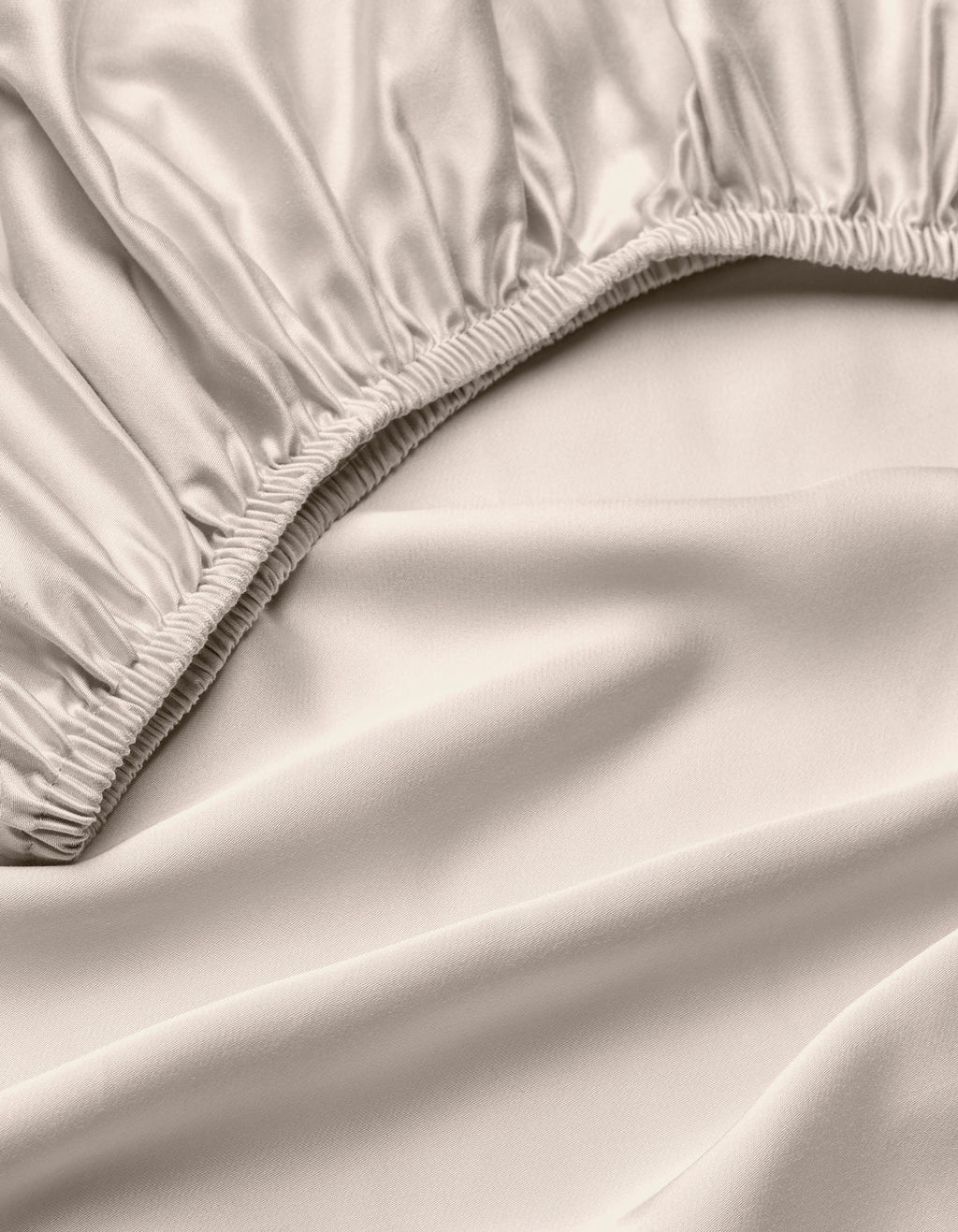 A close-up of the Cozy Earth Bamboo Fitted Sheet in light beige, highlighting its silky, smooth fabric, gathered elastic edges, and soft folds.|Color:Driftwood