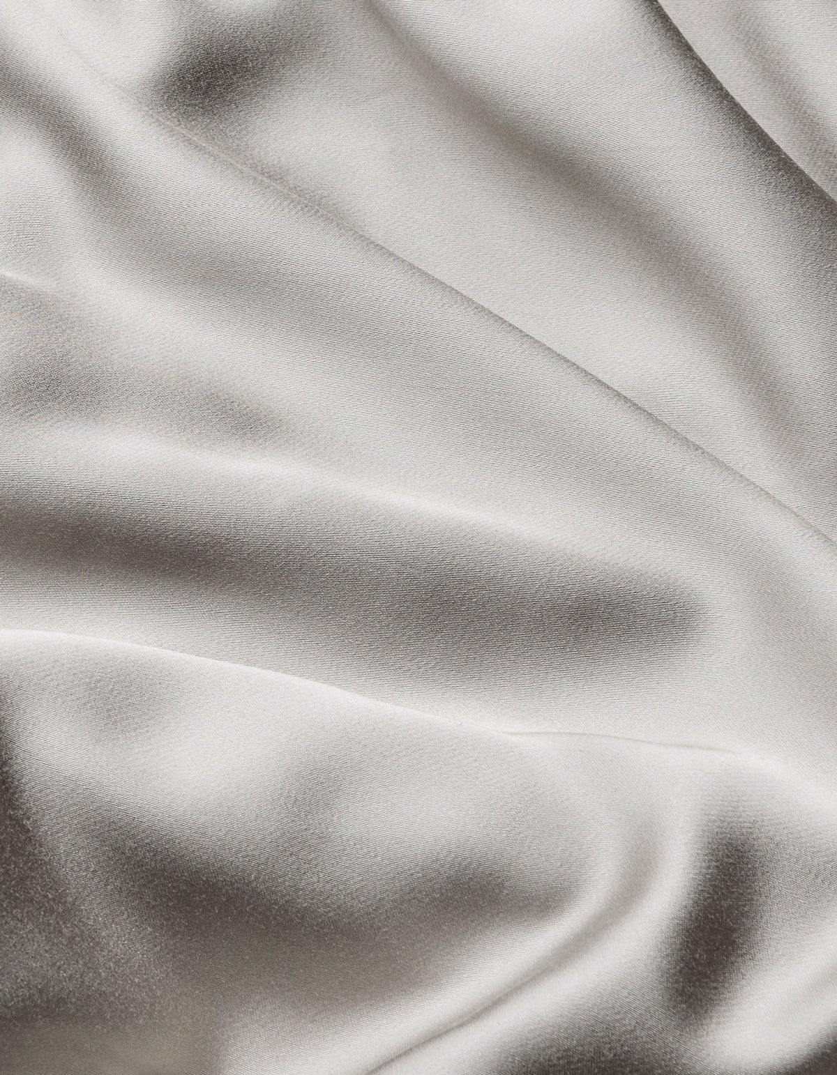 Close-up of Cozy Earth Bamboo Sheet Set featuring smooth, light-colored fabric with gentle folds and a subtle sheen for a soft, elegant texture.|Color:Light Grey