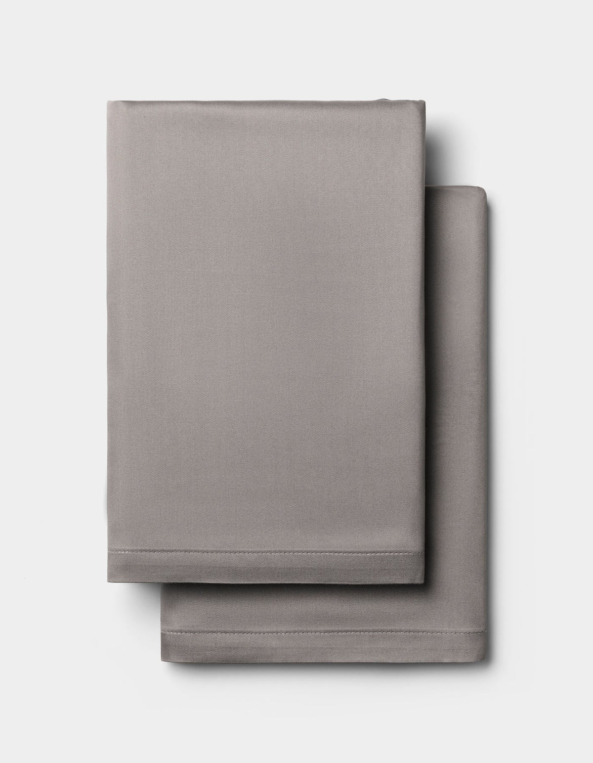 Two light gray Cozy Earth Bamboo Pillowcases, neatly folded and stacked against a plain white background.|Color:Charcoal