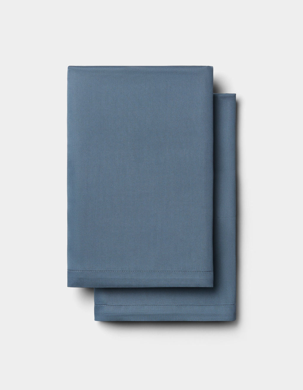 Two neatly folded Cozy Earth Bamboo Bedding Deluxe Bundle - Silk sheets are stacked atop each other against a plain white background.|Color:Pacific Blue