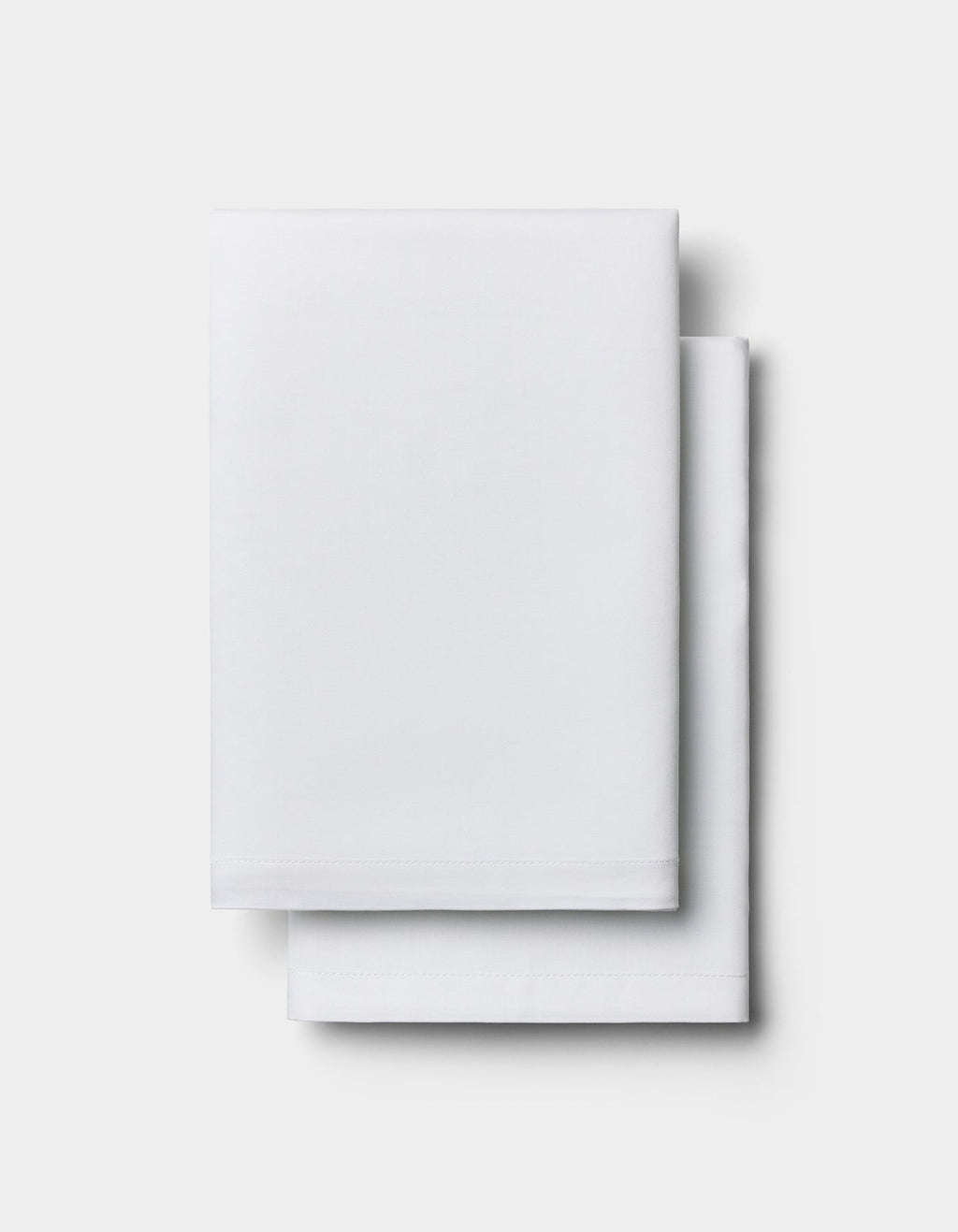 Two neatly folded Cozy Earth Bamboo Pillowcases stacked on top of each other against a plain light background.|Color:White