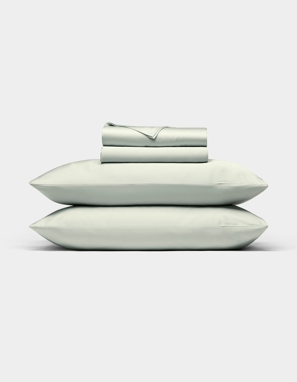The Cozy Earth Bamboo Sheet Set, in light gray, features neatly folded bed sheets with two matching pillowcases stacked on top, displayed against a plain white background.|Color:Laurel