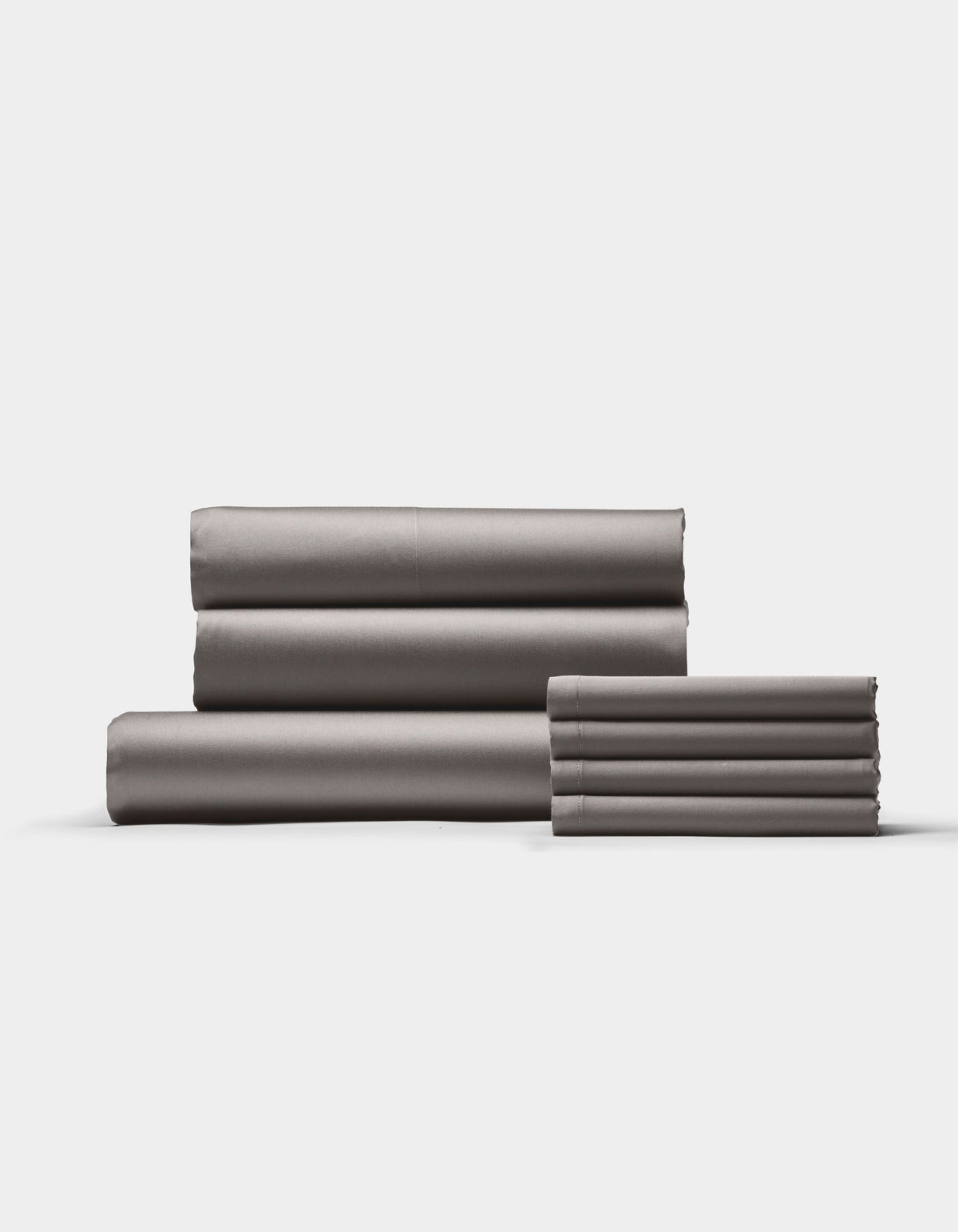 The Cozy Earth Bamboo Bedding Core Bundle features neatly folded gray bed sheets arranged in two stacks against a plain white background.|Color:Charcoal