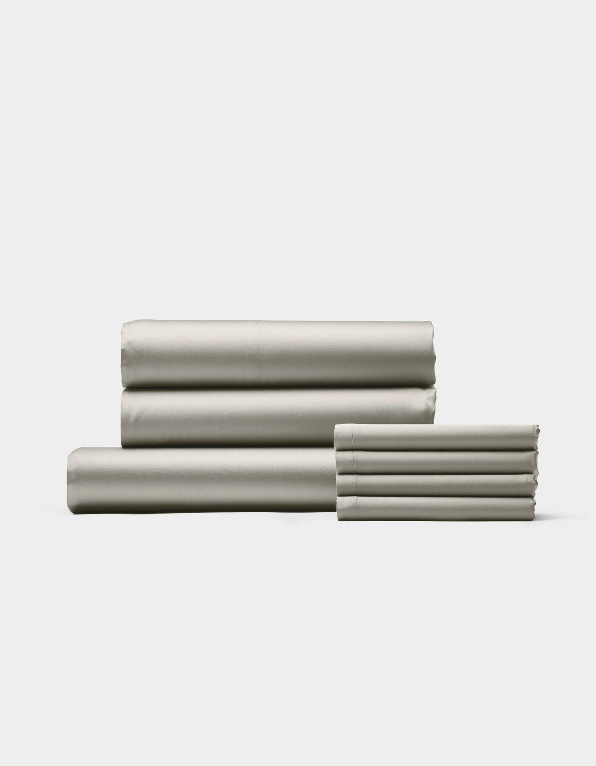 The Cozy Earth Bamboo Bedding Core Bundle, featuring neatly folded light gray sheets and pillowcases, is stacked on a white background with three larger sheets on the left and pillowcases on the right.|Color:Light Grey