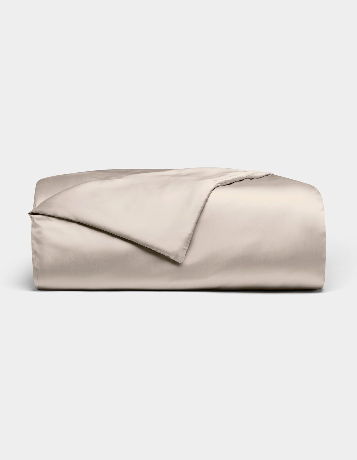 The Bamboo Duvet Cover by Cozy Earth is shown neatly folded in light beige with a smooth, shiny finish against a white background; one corner is flipped open to reveal the inner side.|Color:Driftwood