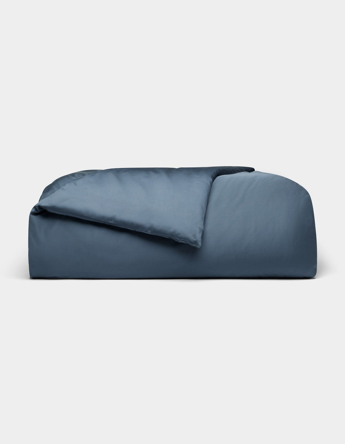 The Cozy Earth Bamboo Duvet Cover, in dark blue and rectangular shape, features plush fabric with a partially folded comforter, displayed against a plain light gray background.|Color:Pacific Blue