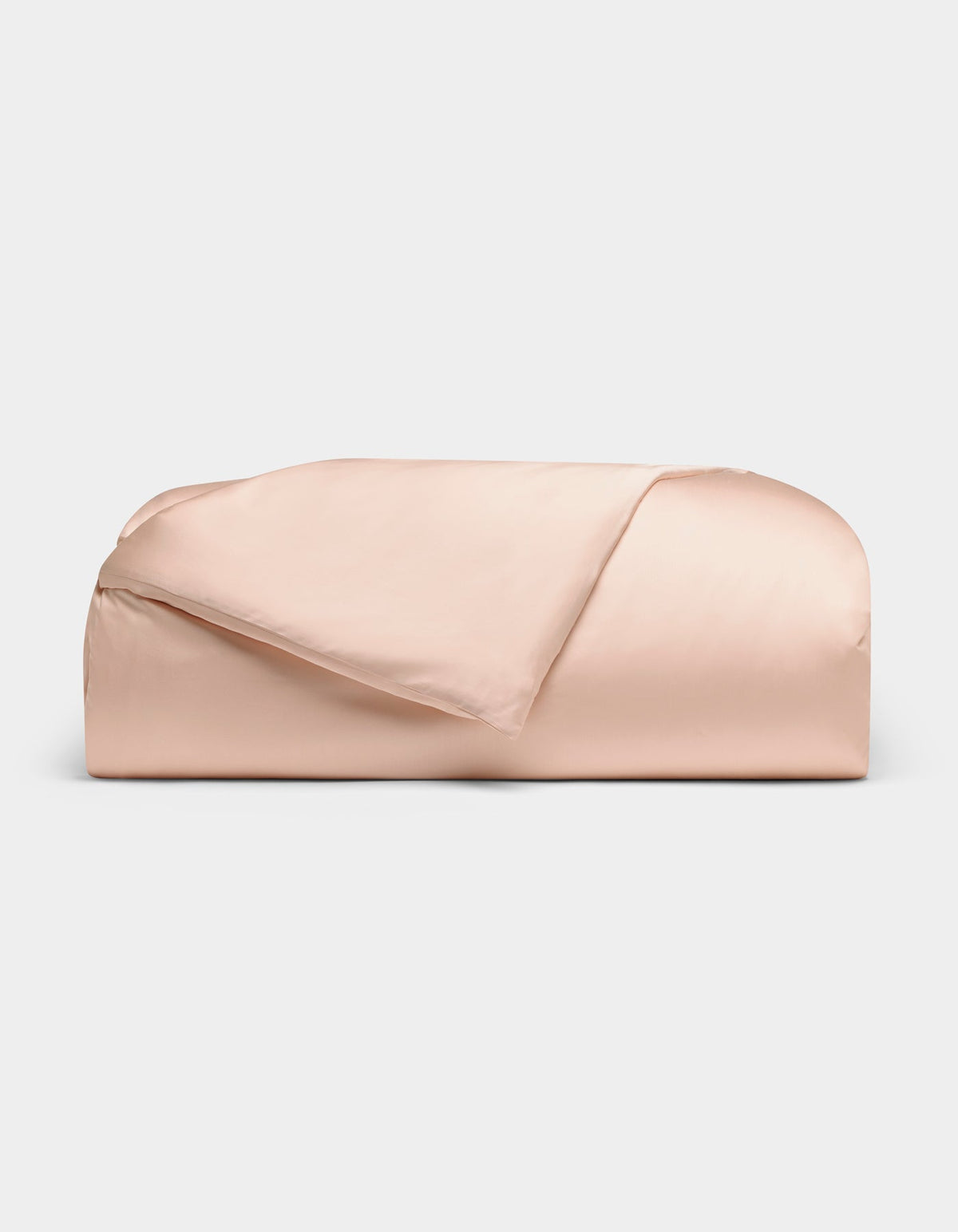 The Cozy Earth Bamboo Duvet Cover, in pale pink, is neatly folded against a plain white background with one corner turned down to reveal its smooth fabric.|Color:Peony