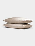 Two Cozy Earth Bamboo Pillowcases in beige are stacked together against a simple light gray background.|Color:Driftwood