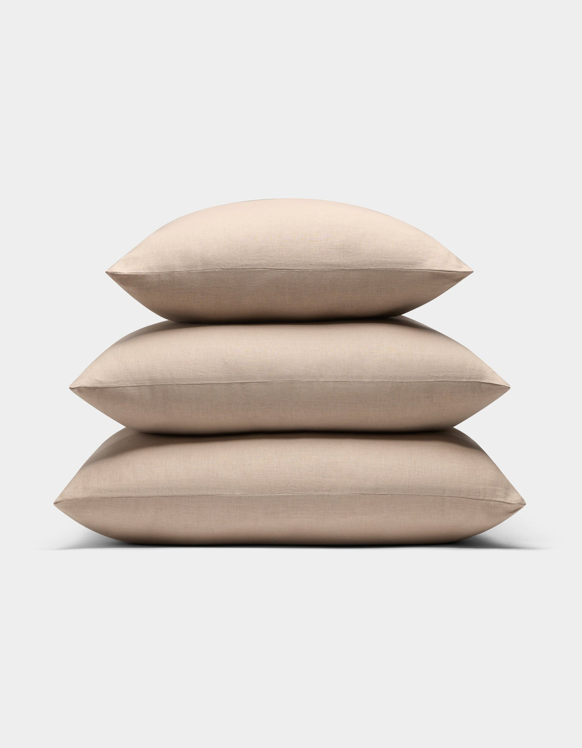 Three Cozy Earth Linen Throw Pillows in beige are stacked neatly against a plain white background.|Color:Birch |Size:26" x 26"