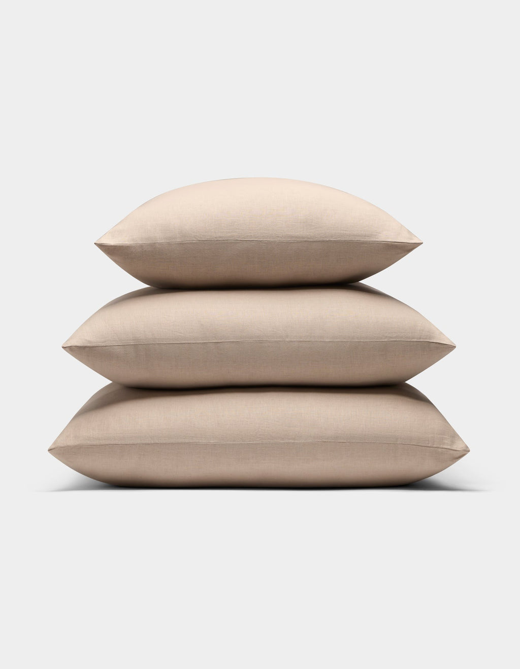Three Cozy Earth Linen Throw Pillows are stacked neatly on top of each other against a plain white background.|Color:Birch |Size:20" x 20"