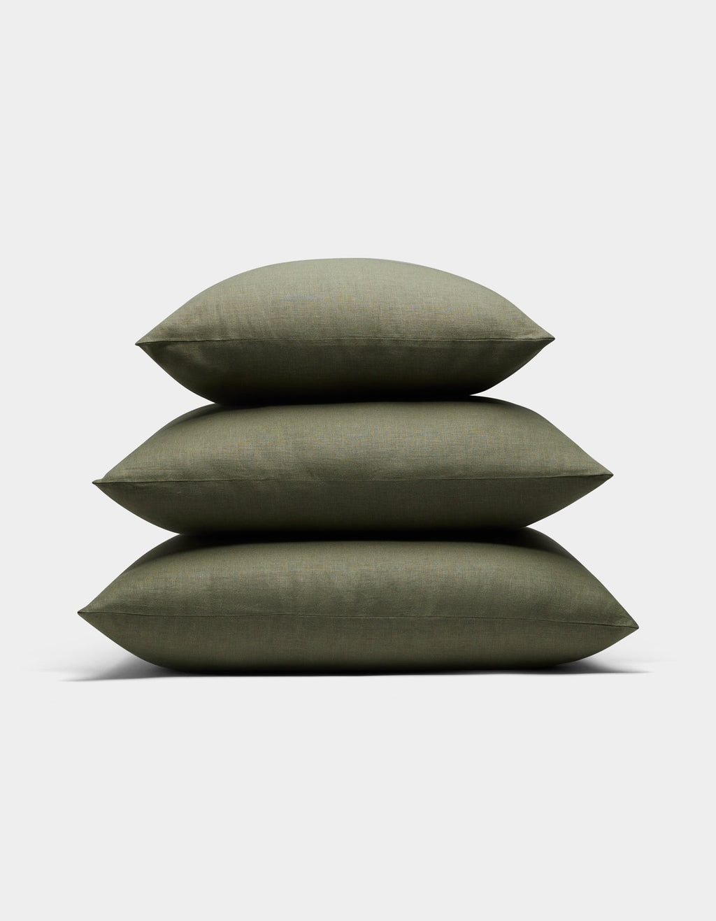 Three Cozy Earth Linen Throw Pillows in olive green are stacked neatly against a plain white background.|Color:Olive |Size:20" x 20"