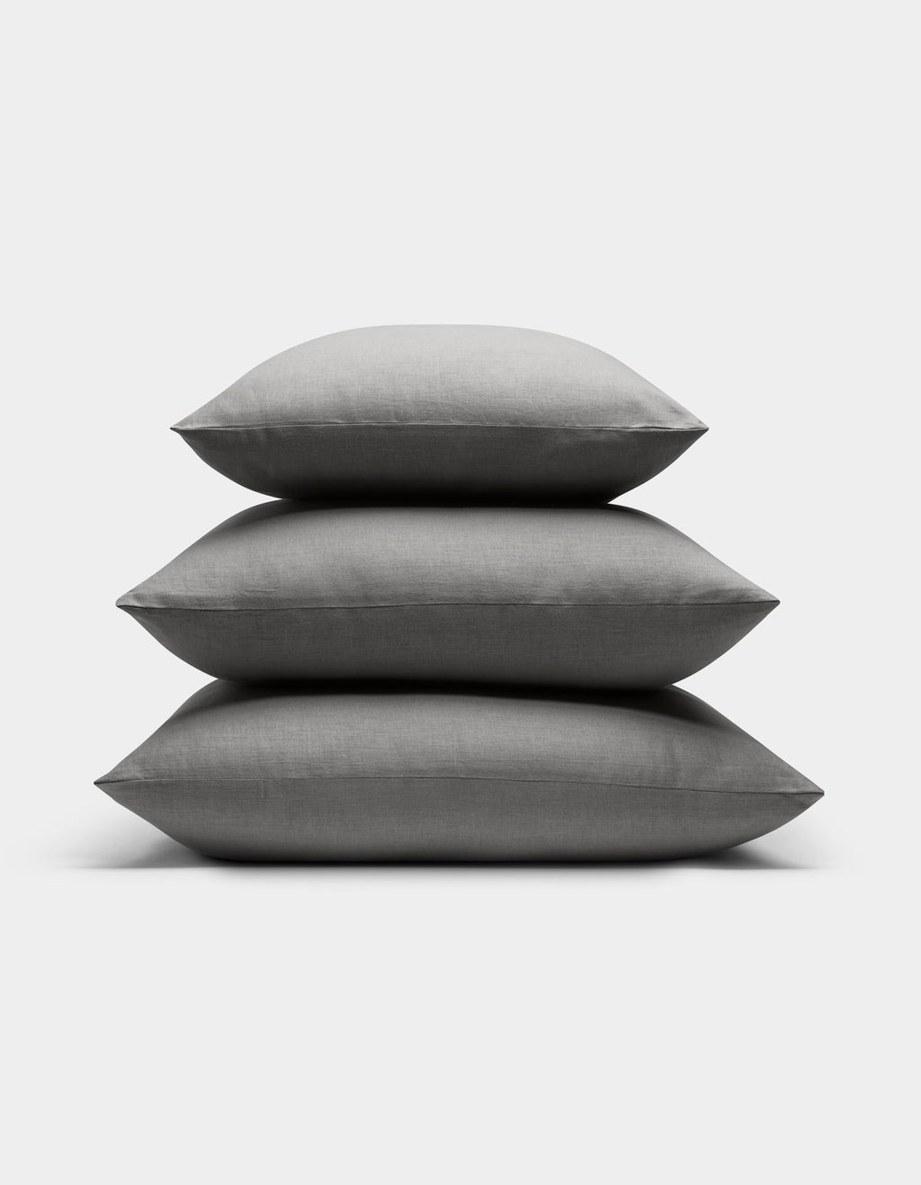 Three neatly stacked Cozy Earth Linen Throw Pillows are displayed against a plain white background.|Color:Steel |Size:24" x 24"