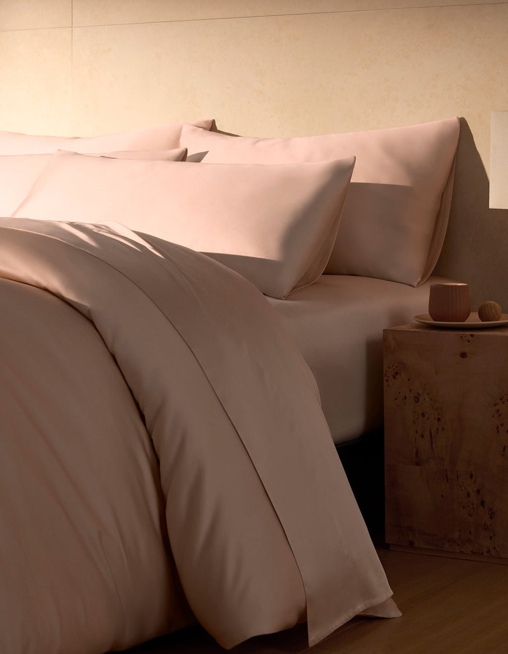 A close-up view of a neatly made bed with pink Bamboo Pillowcases by Cozy Earth, featuring a smooth, soft-looking fabric.|Color:Peony