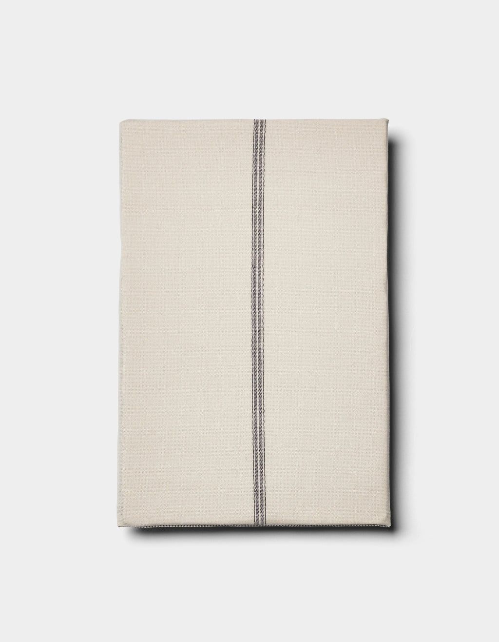 The Cozy Earth Baja Double Sided Sham is shown neatly folded in beige, featuring a single off-center vertical black stripe, set against a plain light background.|Color:Coal Stripe/Striped Alabaster