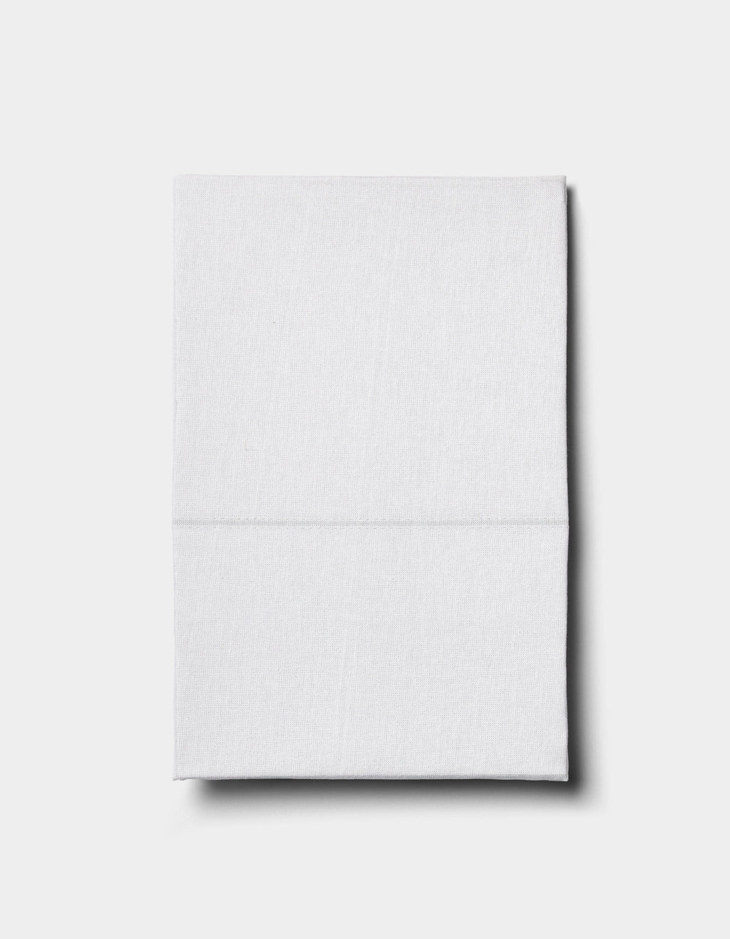The Baja Double Sided Sham by Cozy Earth, neatly folded, rests on a plain light gray surface and casts a subtle shadow to the right.|Color:Laurel Stripe/Striped Bone