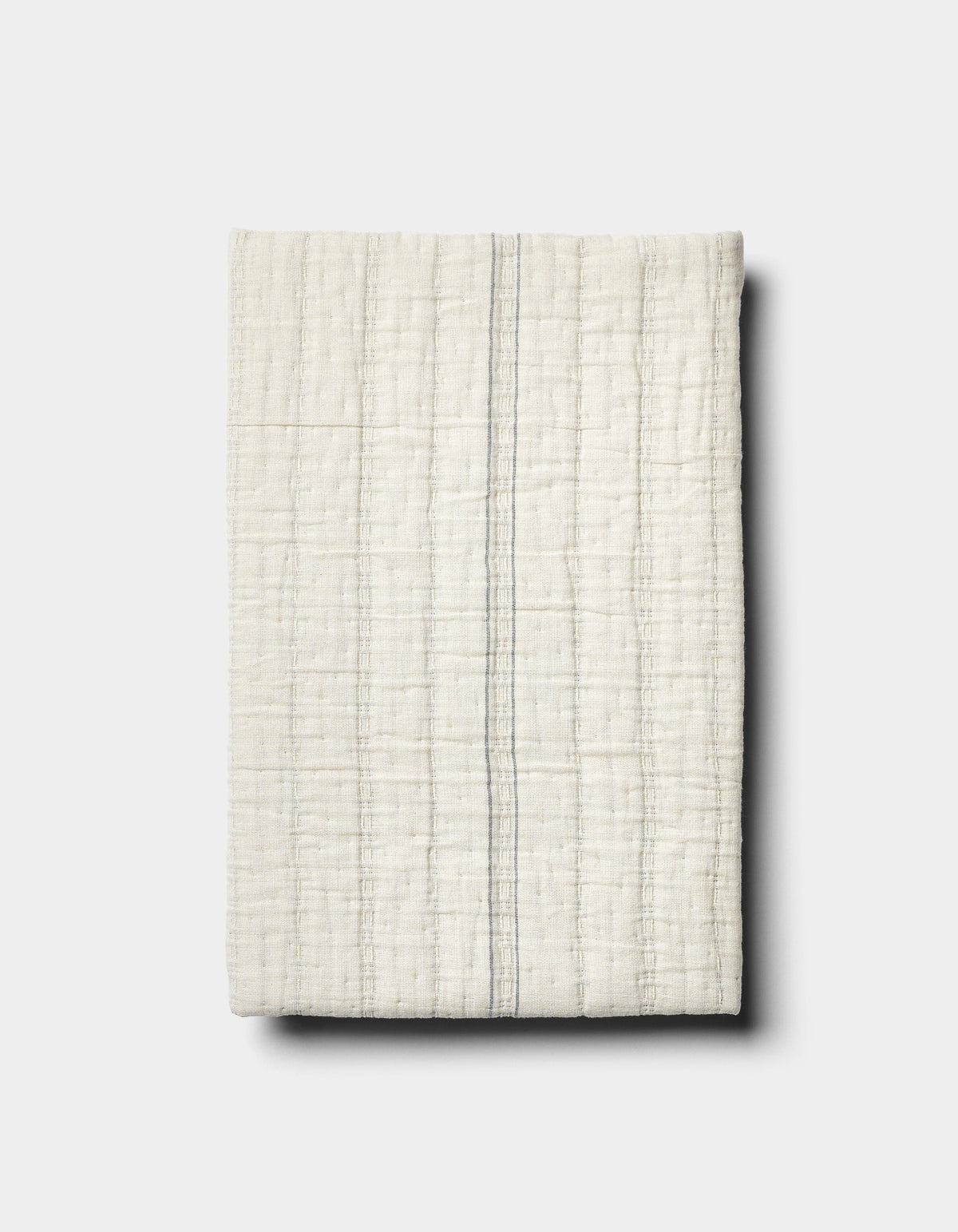 The Baja Matelasse Sham by Cozy Earth features off-white textured fabric with a subtle grid pattern and a single thin grey vertical stripe, displayed on a light grey background.|Color:Alabaster/Oceanside
