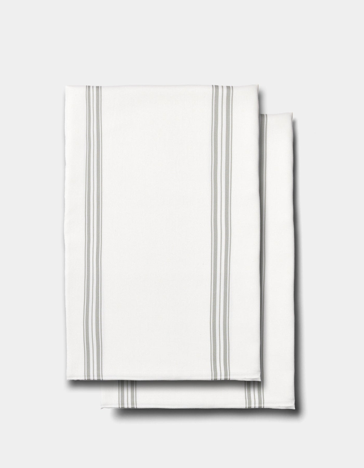 Two neatly folded Cozy Earth Bamboo Pillowcases in white, featuring thin gray vertical stripes along the edges, displayed on a plain light gray background.|Color:Baja Stripe in Laurel