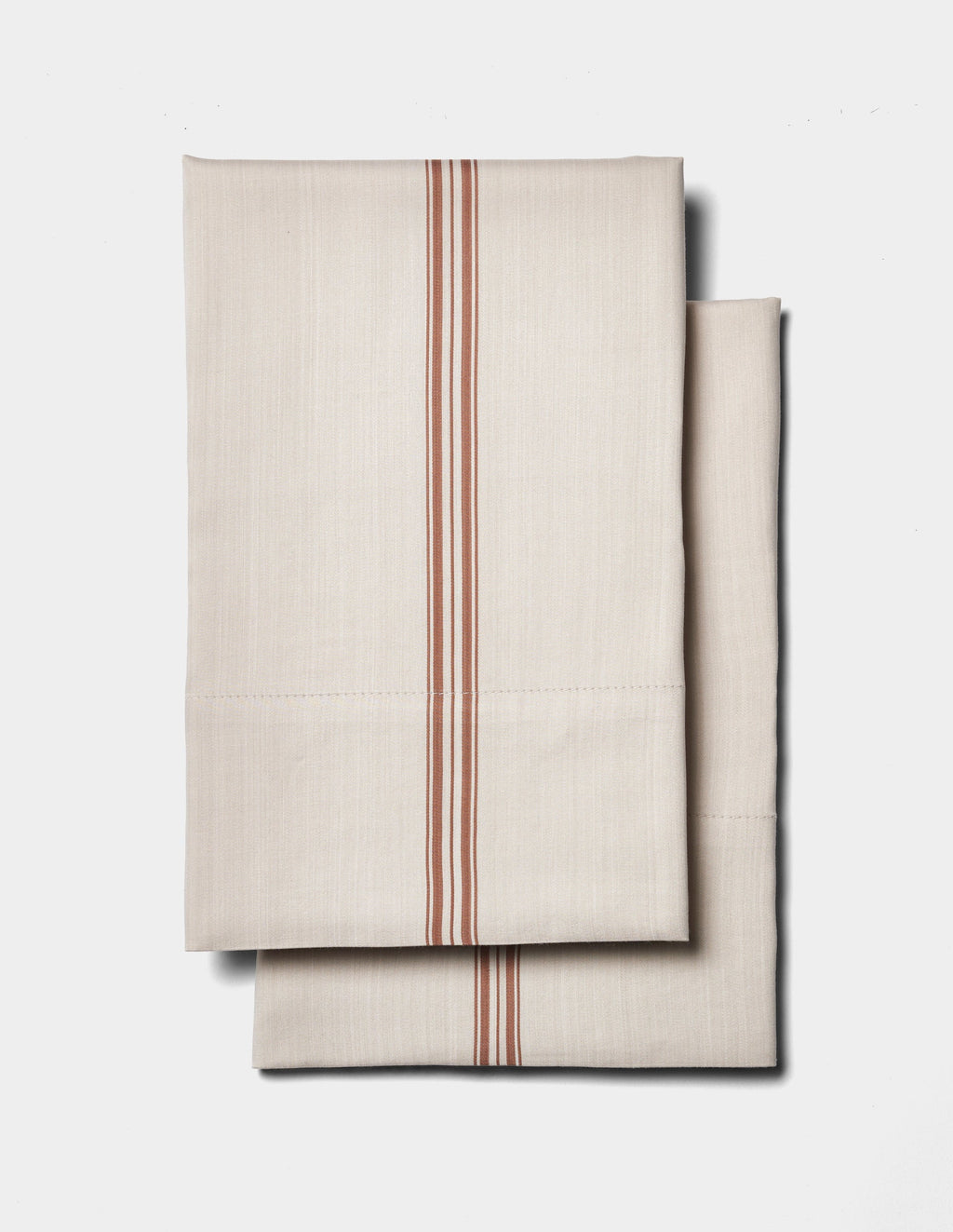 Two folded Cozy Earth Bamboo Pillowcases in beige with vertical red stripes are displayed on a plain white background.|Color:Baja Stripe in Maple