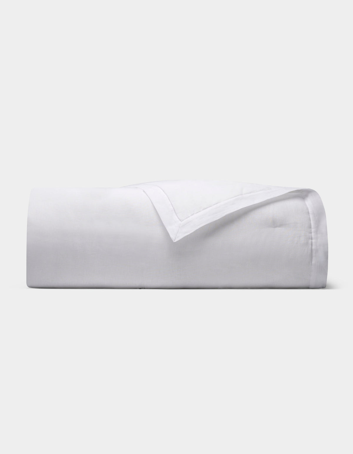 The Cozy Earth Linen Quilt, featuring a smooth texture, is neatly folded and displayed against a plain light gray background.|Color:White