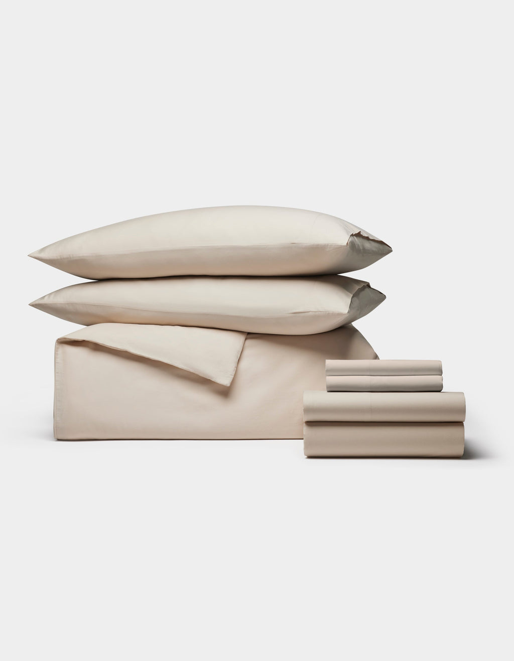 The Cozy Earth Soft-Wash Cotton Bedding Core Bundle features beige sheets, a flat sheet, two pillowcases, and two pillows, all neatly stacked and displayed against a plain white background.|Color:Driftwood