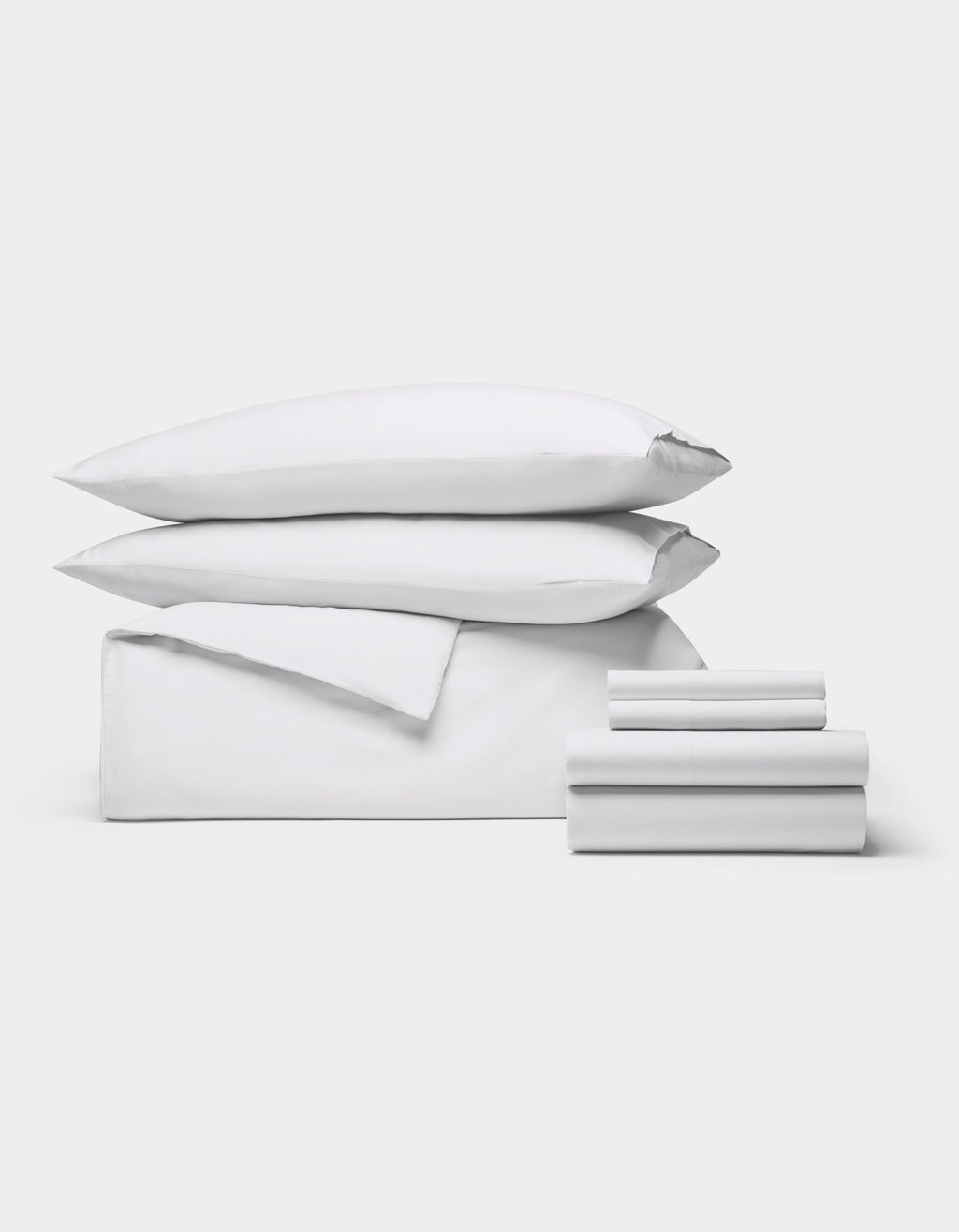 The Cozy Earth Soft-Wash Cotton Bedding Core Bundle features two pillows, a folded duvet, and several neatly stacked sheets, all displayed against a plain white background.|Color:White