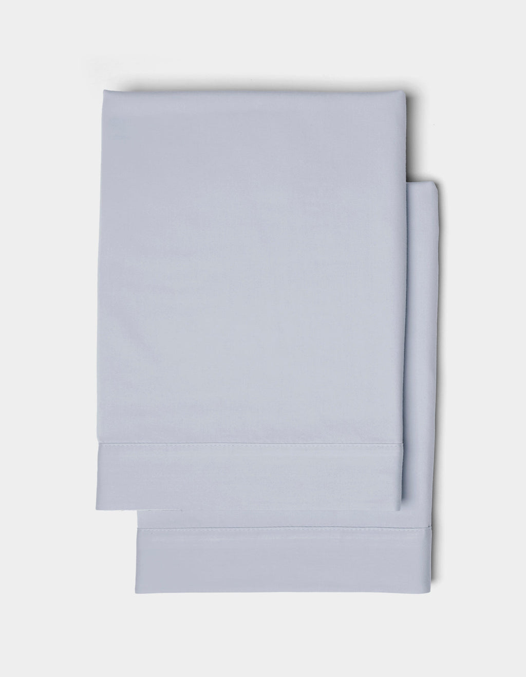 Two neatly folded Cozy Earth Soft-Wash Cotton Shams in light blue are stacked together against a plain white background.|Color:Shore